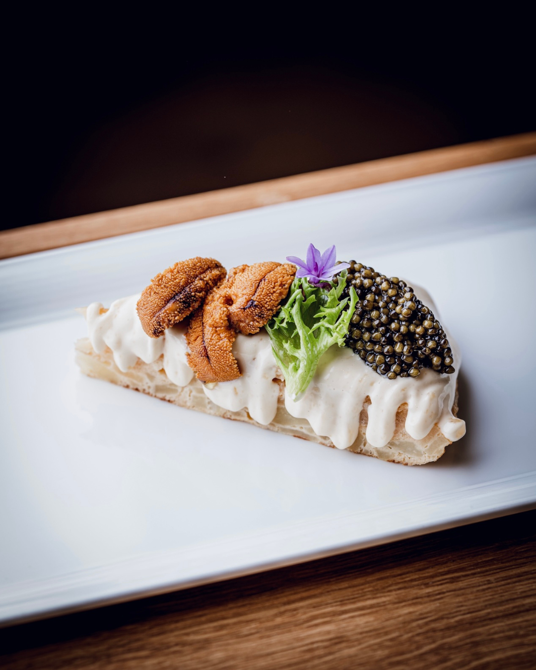 Black caviar served on crackers with butter for a caviar tasting at home