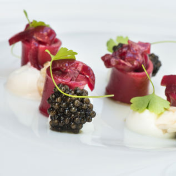 Close-up of caviar served on creamy truffle-infused risotto garnished with fresh herbs