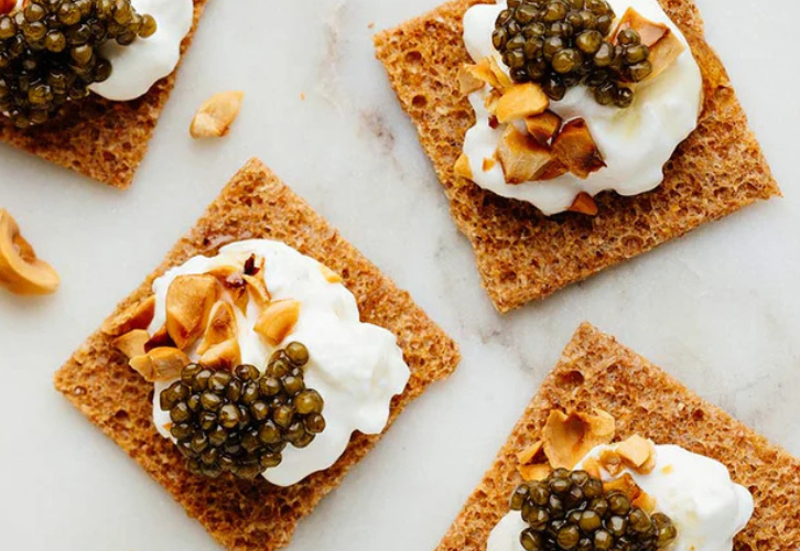Burrata topped with Royal Oscietra Caviar and toasted hazelnuts on crisp toast squares