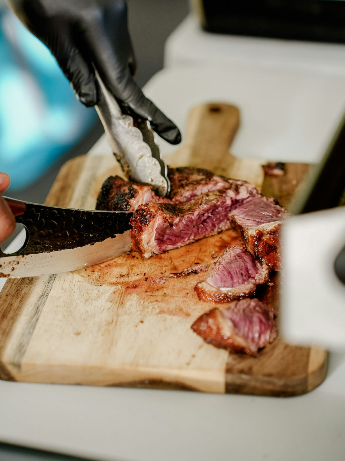 Chef slicing a cooked steak on a wooden board