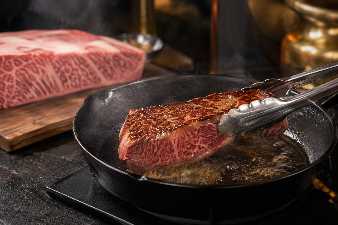 Marbled Japanese-style steak searing in a cast-iron pan for a Kobe Beef cooking guide