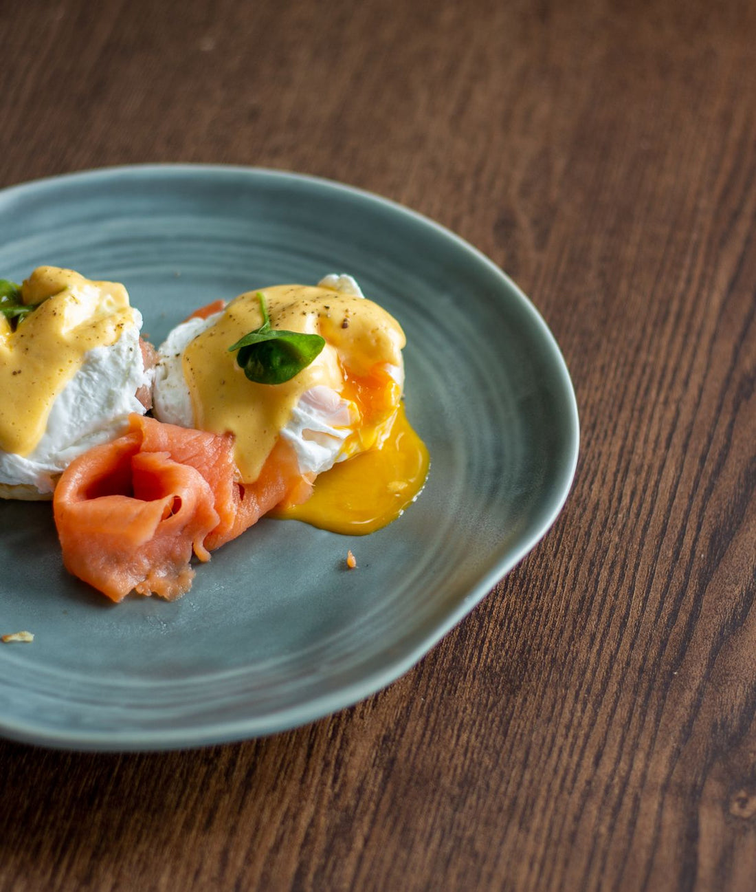 Eggs Benedict with smoked salmon and hollandaise on a ceramic plate