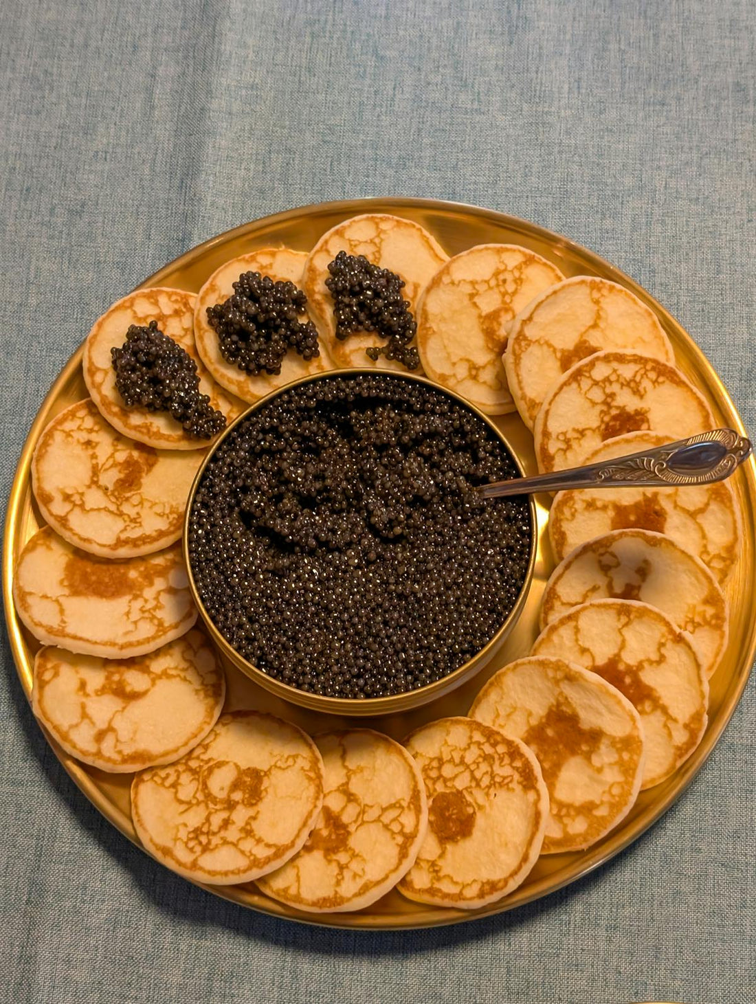 Close-up of ridged potato crisp topped with creme fraiche and Oscietra caviar at a party