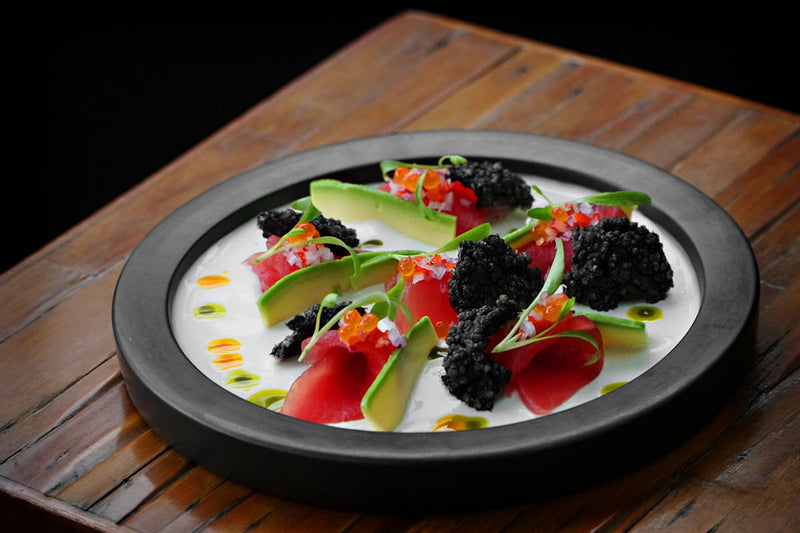 Caviar scrambled eggs plated with golden Oscietra caviar on creamy soft scrambled eggs