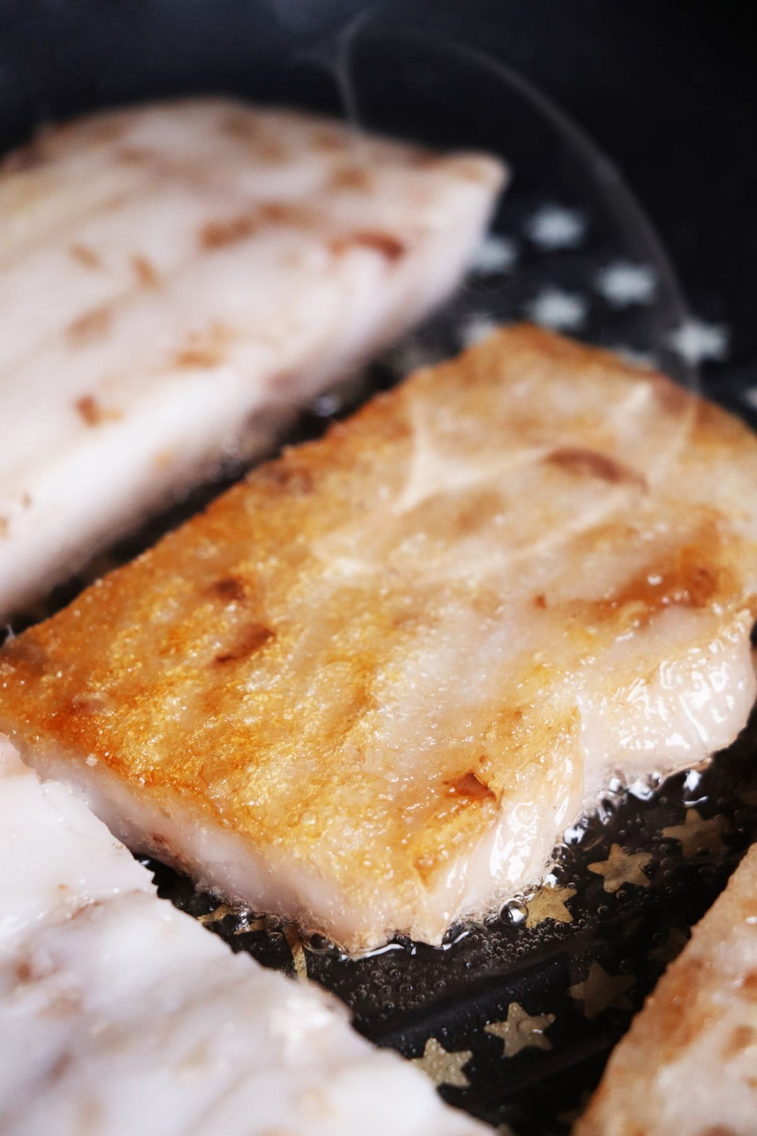 White fish fillet frying to a golden crust in butter