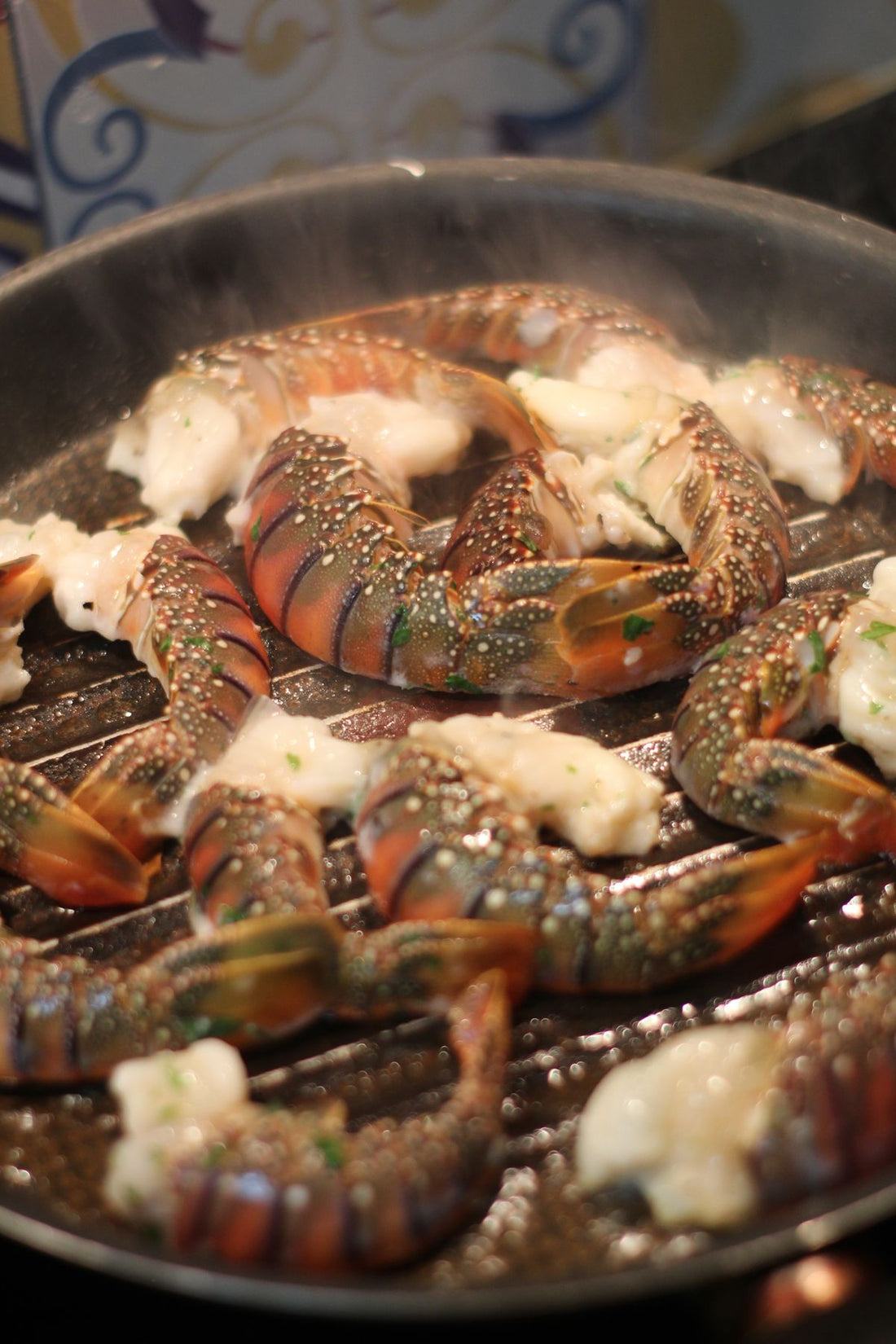 Lobster tails roasting with butter and herbs, steam rising