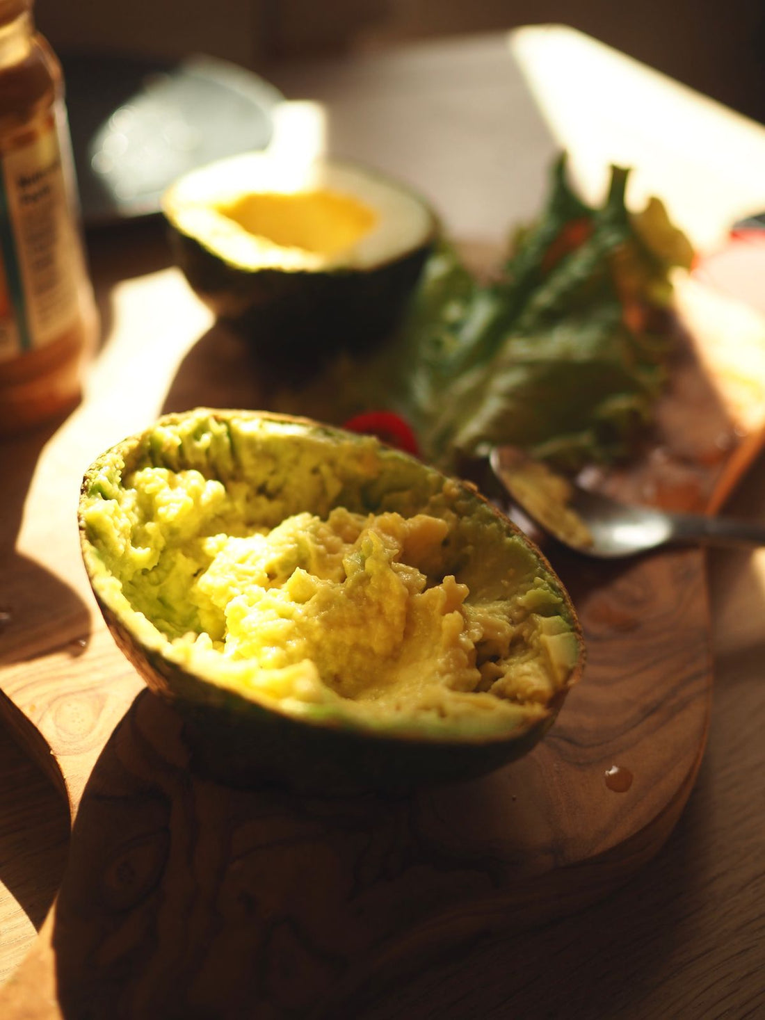 Ripe avocado being mashed with a spoon
