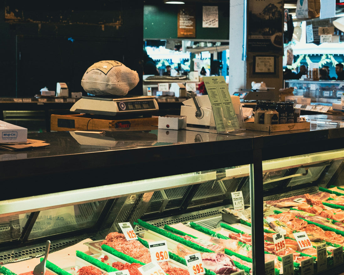 Butcher counter with meat and a weighing scale; editorial image for portion planning