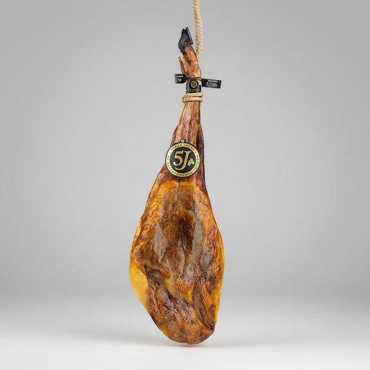 Cured ham on a marble background with a visible brand label.