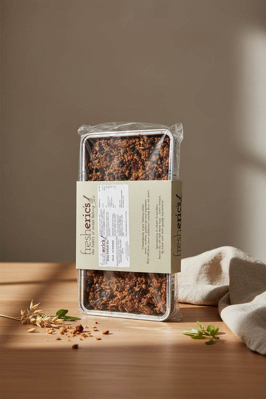 Granola Slice Traybake with nuts, cranberries, and oats on a white plate