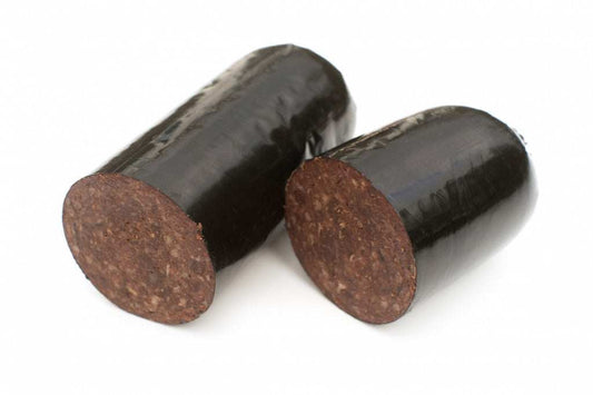 Sliced black pudding stick on wooden board
