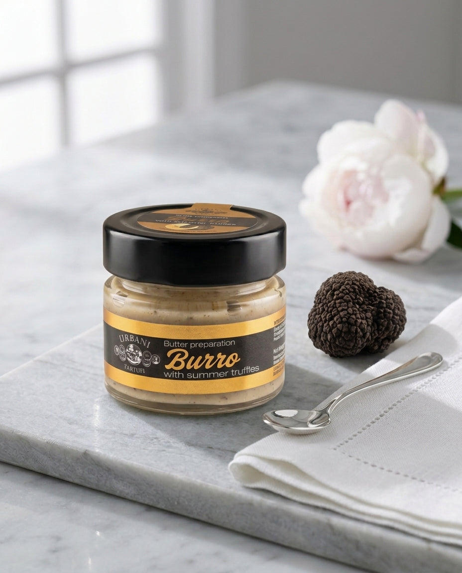 Black Truffle Butter 70gr packaged in a jar with a spoon and fresh truffle slices.