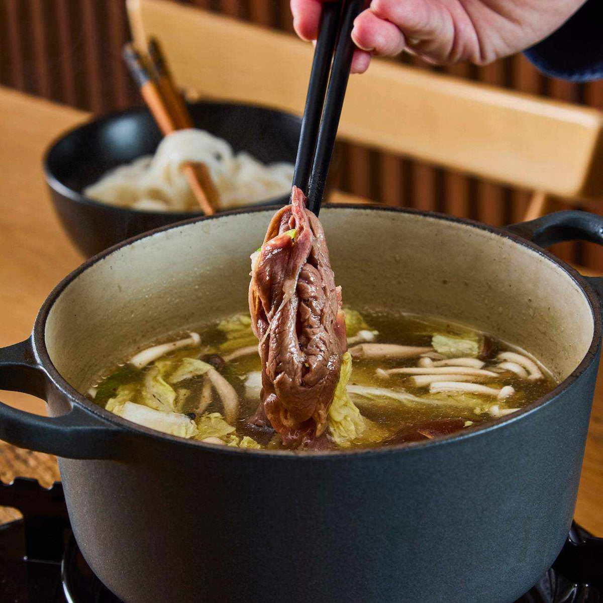 British Wagyu Beef thinly sliced brown meat lifted from a Japanese hot pot with vegetables