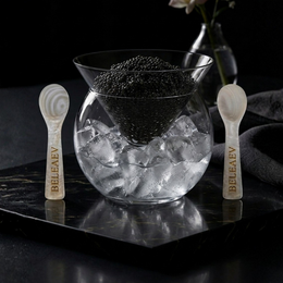 Beleaev Glass Caviar Chiller Set with hand-blown glass bowl and mother-of-pearl spoons on crushed ice base
