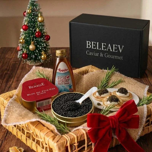 Luxury Christmas hamper featuring Oscietra Royal caviar, Rougié foie gras with truffles, hot honey, and blinis in a wicker basket