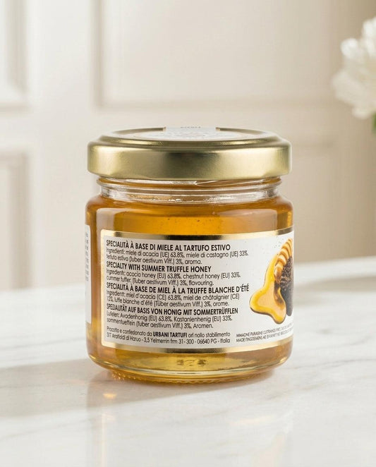 Jar of Summer Truffle Honey 90gr with honey dipper on wooden surface