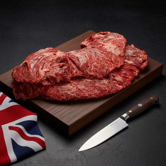 Wagyu British Beef whole bavette d'Aloyau cut with moderate marbling on a wooden board alongside a cutting knife and British flag cloth