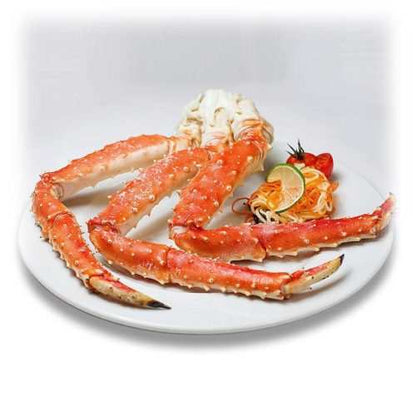 XXL Norwegian king crab clusters cooked frozen with lemon wedge